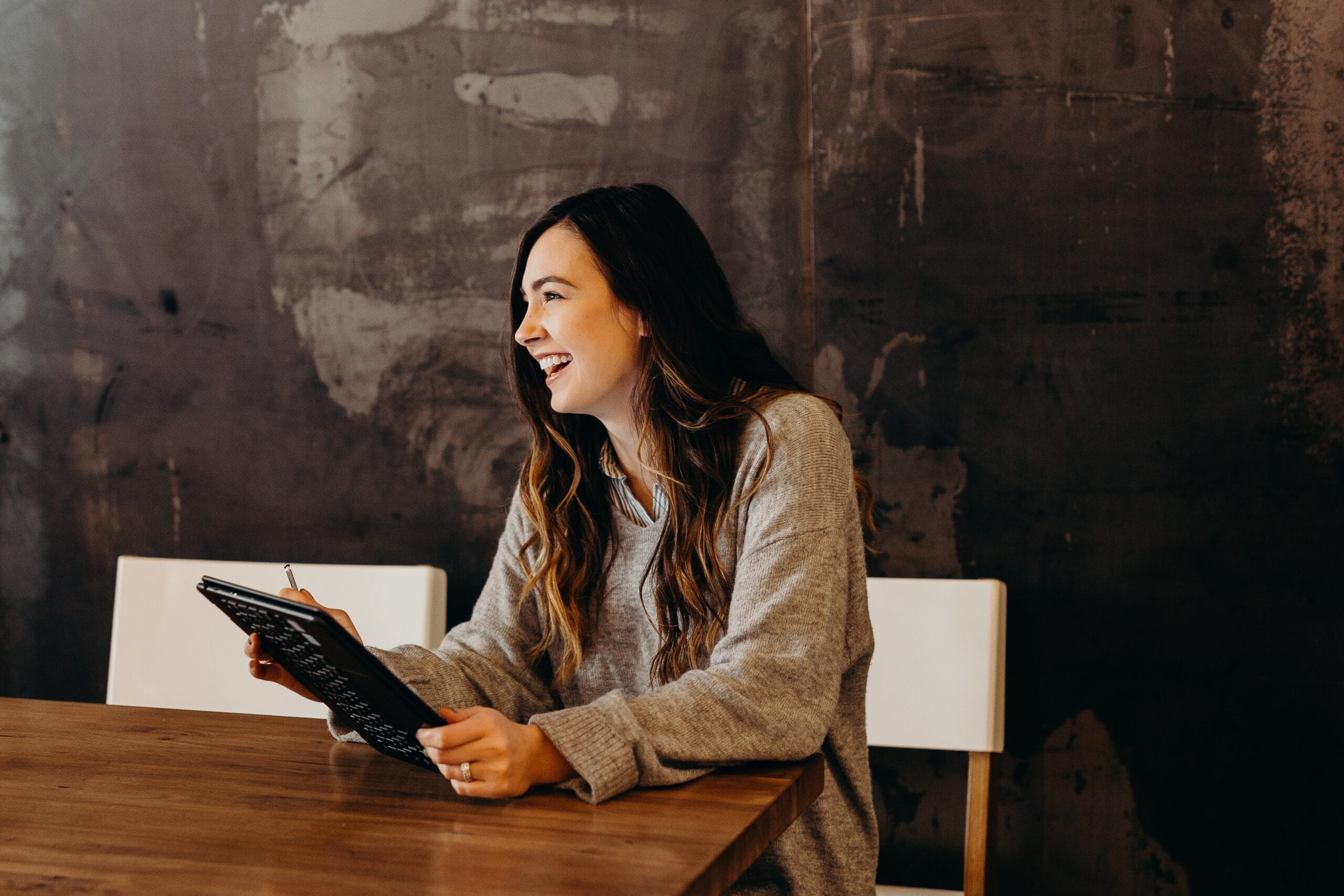 woman smiling and holding an iPad