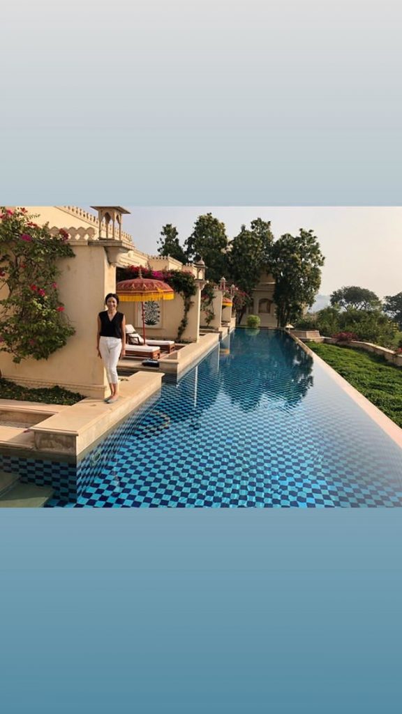 Cass in front of pool at resort in India