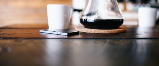 coffee pot next to a phone and mug
