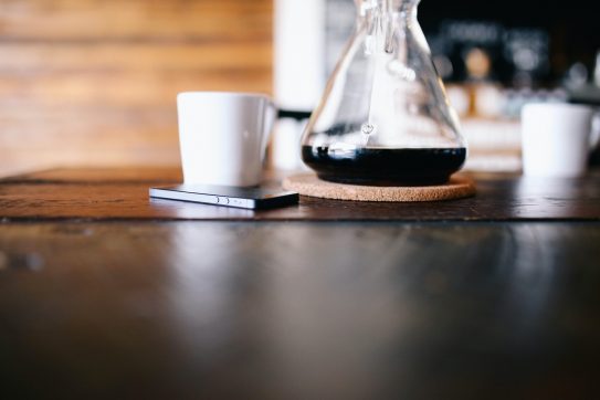coffee pot next to a phone and mug