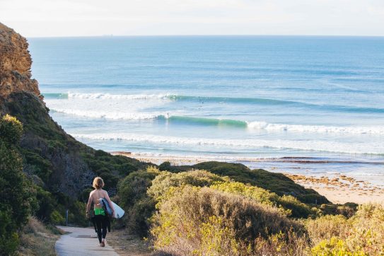surfer walking toward the ocean