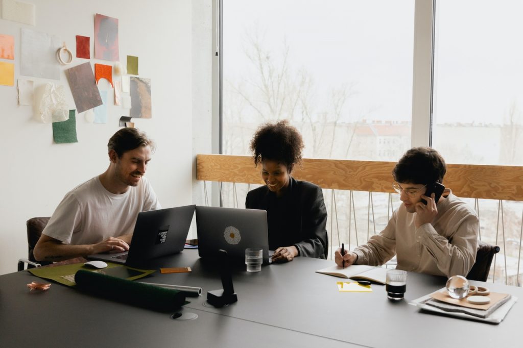 three people smiling while working