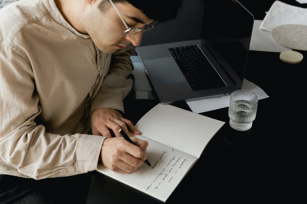 man writing in a notebook