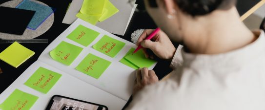 person writing on sticky notes