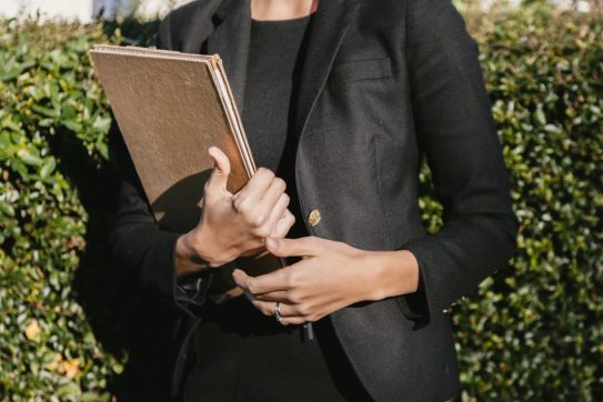 person in suit holding paperwork