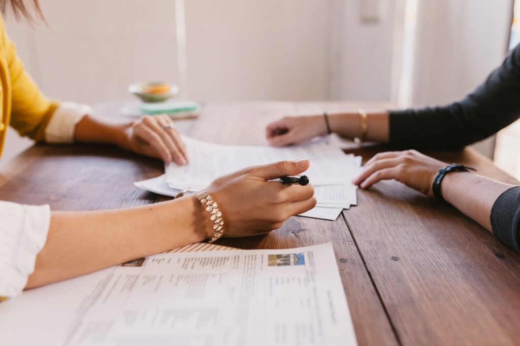 two people signing paperwork