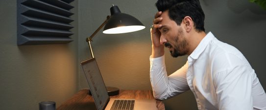 stressed man looking at a computer