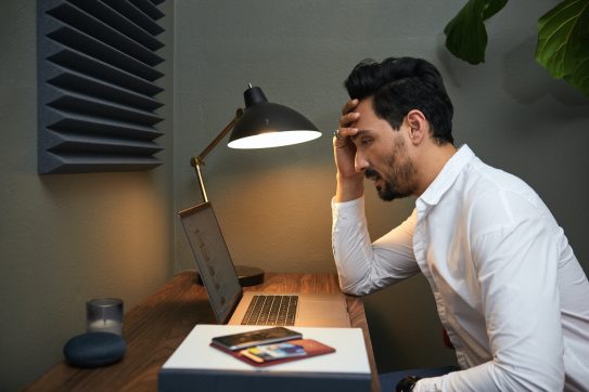 stressed man looking at a computer