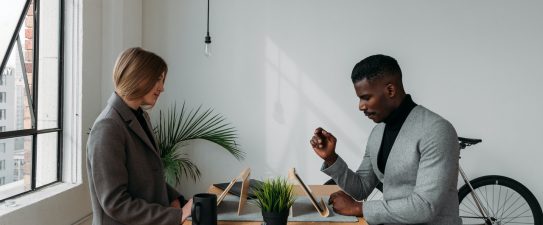 Two people working across a desk