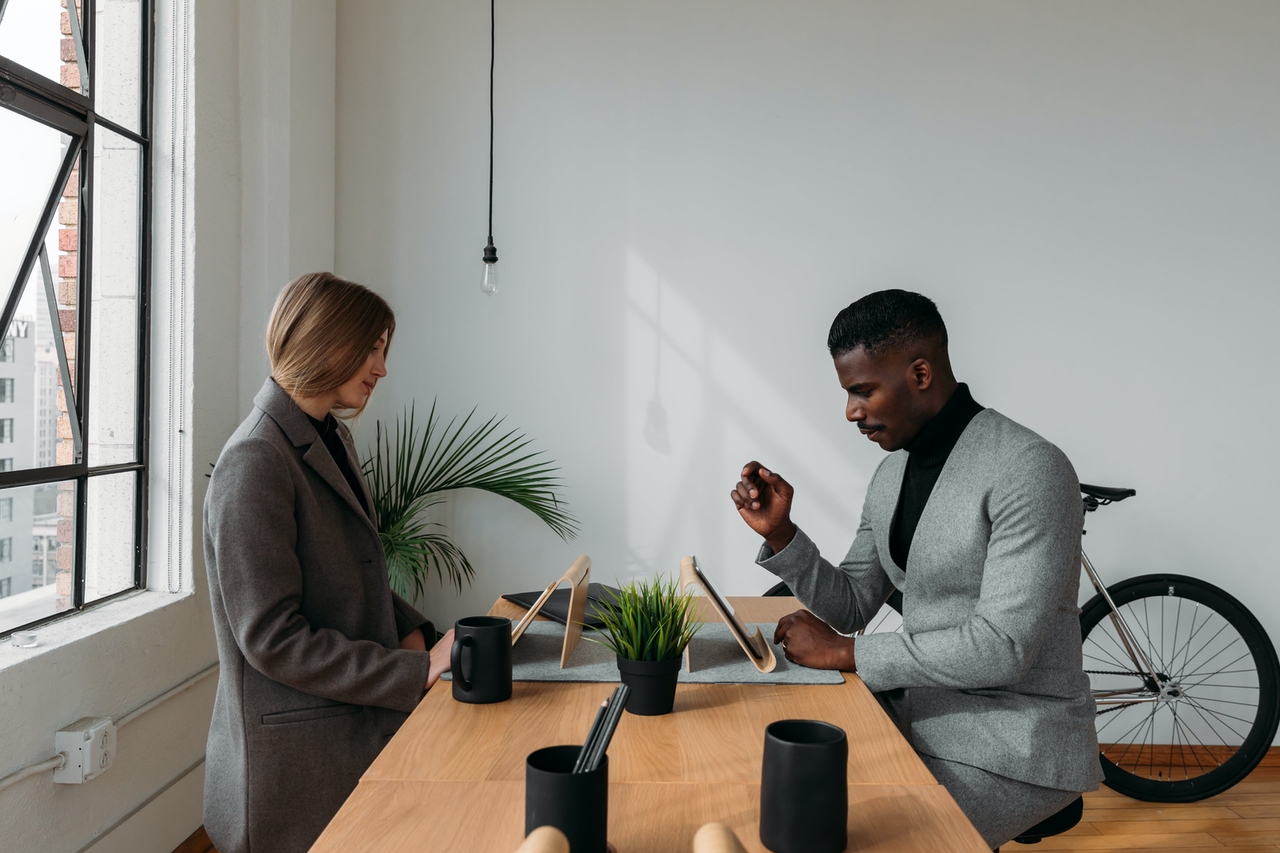 Two people working across a desk