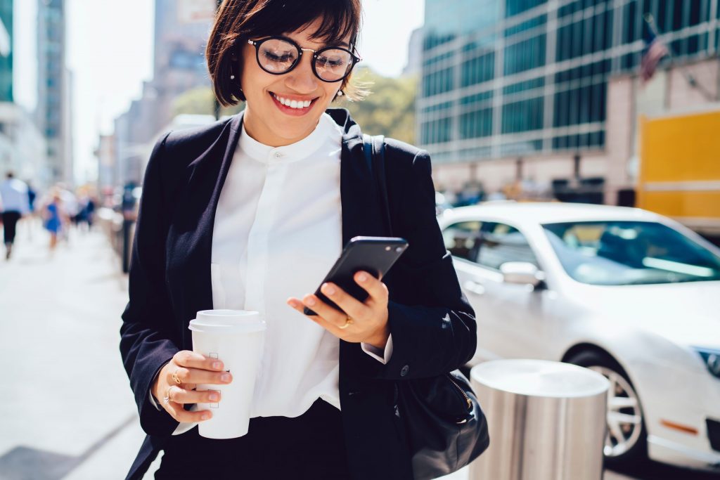 woman in business attire looking at her phone