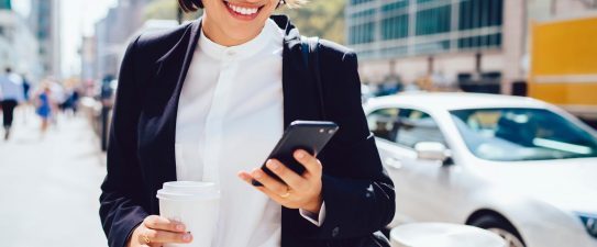 woman in business attire looking at her phone