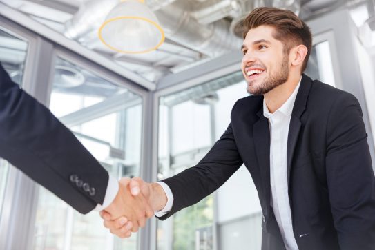 man shaking hands with someone off camera