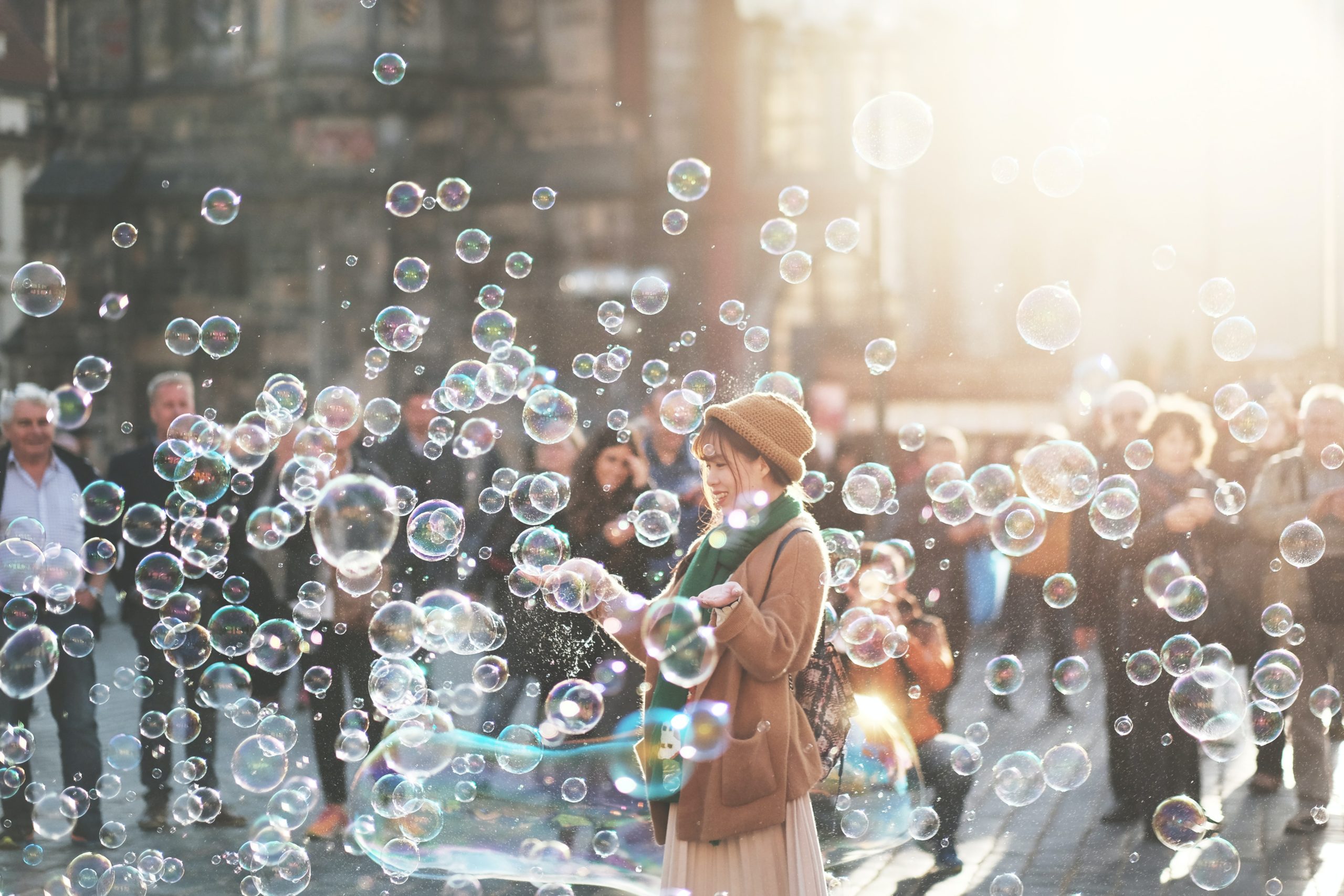woman standing in crowd blowing bubbles