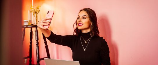 woman taking a selfie in front of laptop