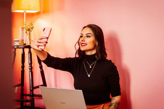 woman taking a selfie in front of laptop