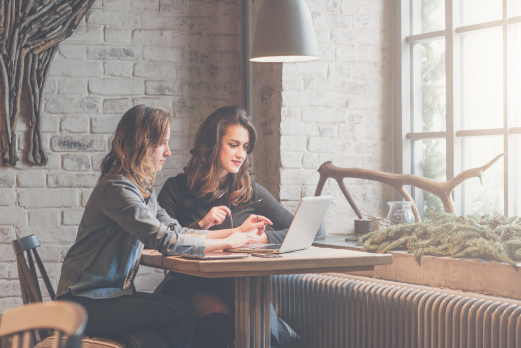 mentor and mentee working together in a coffee shop