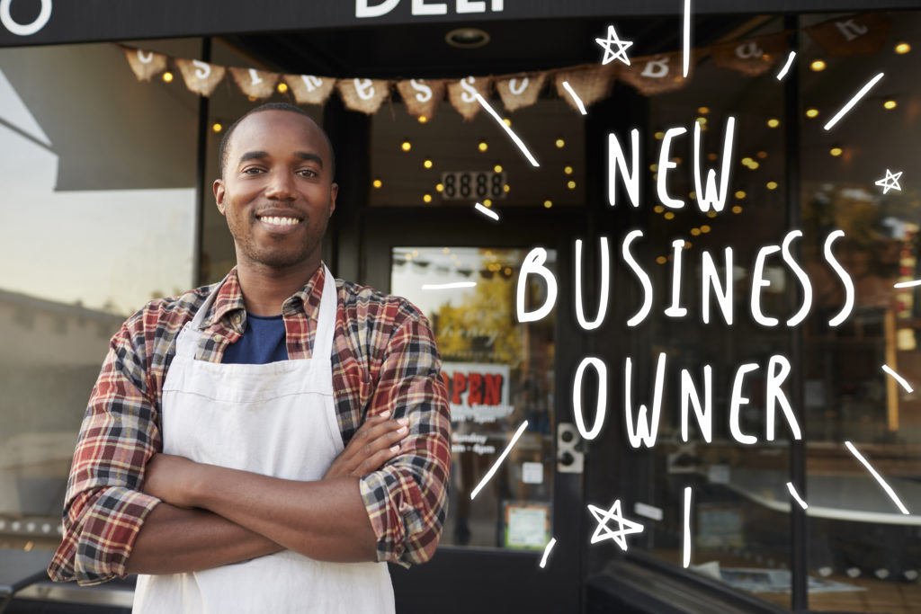 Man standing outside cafe that says "new business owner"